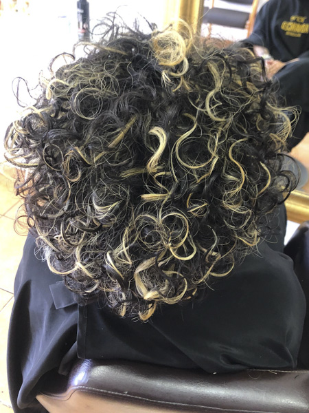 pelo negro rizado con mechas rubias